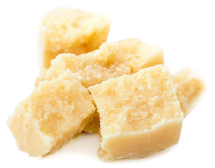 Heap of parmesan cheese pieces isolated on white background, close up