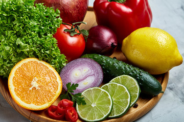 Ripe fresh fruits in a wooden plate on a light background, selective focus, close-up, top view