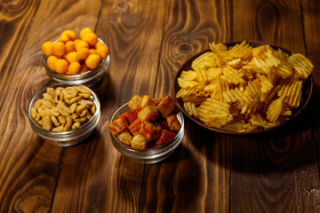 Mix of snacks for beer on wooden table