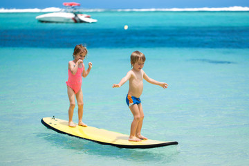Twins brother and sister to have fun with surfing in the ocean