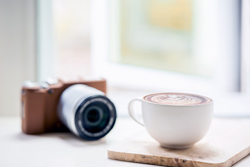 cup of coffee latte and classic camera on white table