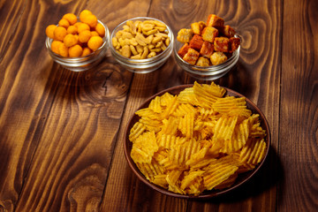 Mix of snacks for beer on wooden table