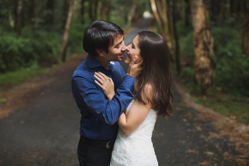 bride and groom newlyweds kissing in woods on green background Wedding Day