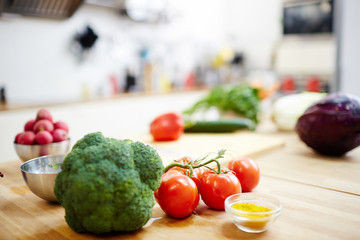 Ripe tomatoes, broccoli, dry karri and other ingredients on workplace of chef