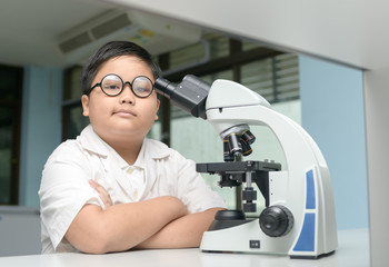 smart boy working with microscope in laboratory
