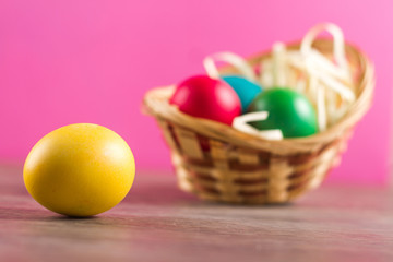 Fototapeta na wymiar Easter eggs in the easter basket on the bright background