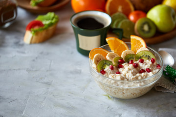 Breakfast still life with oatmeal porridge, fruits and coffee cup, top view, selective focus, shallow depth of field.