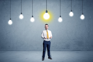 Obraz premium Handsome businessman in an empty space with bulbs above and uninspired face 