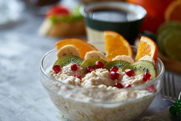 Breakfast still life with oatmeal porridge, fruits and coffee cup, top view, selective focus, shallow depth of field.
