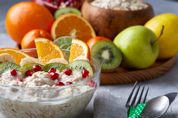 Breakfast still life with oatmeal porridge and fruits, top view, selective focus, shallow depth of field.