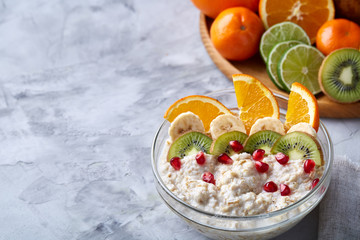 Breakfast still life with oatmeal porridge and fruits, top view, selective focus, shallow depth of field.
