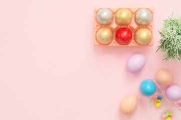 Flat lay top view colorful easter egg painted in pastel colors composition and spring flowers on pink pastel color background. Easter day background top view with copy space.