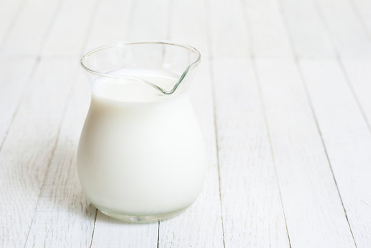 Milk jug on white wooden table