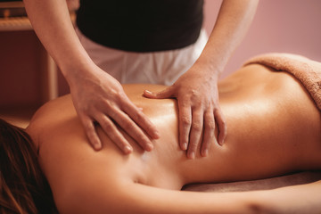 Fototapeta na wymiar a masseur doing massage of back for girl