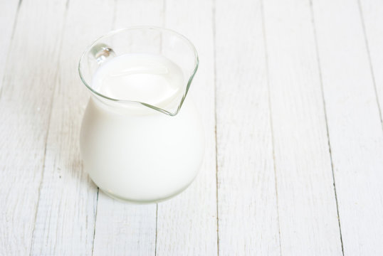Milk jug on white wooden table