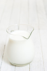 Milk jug on white wooden table