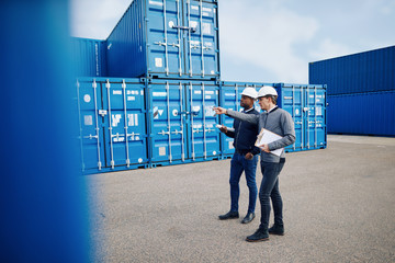 Two engineers tracking shipping inventory in a freight container