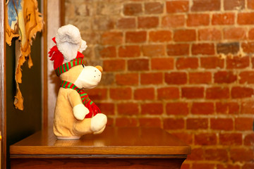Children's Christmas toy dog sitting on the Cabinet against a brick wall.