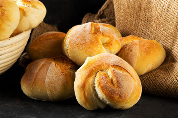 Bunch of whole, fresh baked wheat buns on dark wooden table