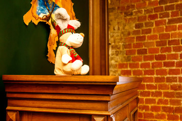 Children's Christmas toy dog sitting on the Cabinet against a brick wall.