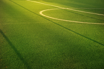 center of green football or soccer field for match or tournament with white line and morning sun light background © bidala