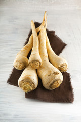 fresh harvested parsley roots on white wooden kitchen plate, can be used as background