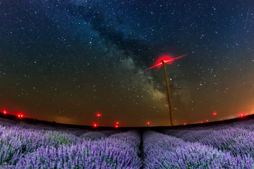 Rolgordijnen Beautiful starry night sky with milky way over a field of lavender and red lights of wind turbines, Bulgaria © mihaelastancu