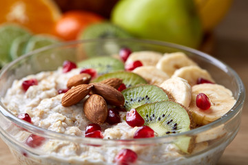 Breakfast still life with oatmeal porridge and fruits, top view, selective focus, shallow depth of field.