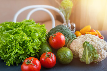 Mixed vegetables of cauliflower and broccoli, garlic, green onions, tomatoes and green peas on a wooden table in the kitchen to prepare vegetarian dishes.