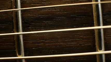Close up macro of guitar strings and fret board
