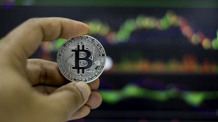 The silver bitcoin with trading graph background