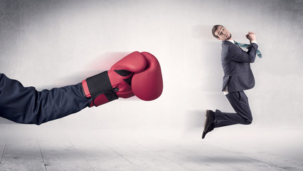 Huge Boxing Gloves punches innocent businessman concept
