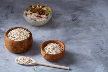 Diet breakfast oatmeal with fruits, bowl and spoon with oat flakes, selective focus, close-up
