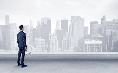 Businessman standing with his back on a roof with objects in his hand  © ra2 studio