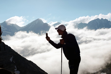 Man tourist takes pictures on mobile phone.