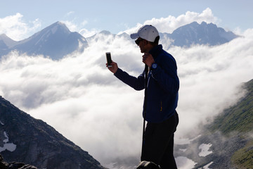 Man tourist takes pictures on mobile phone.