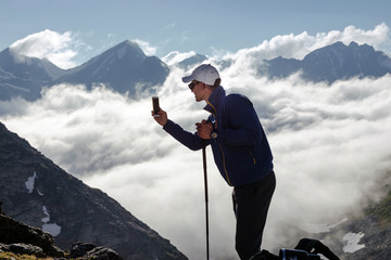 Man tourist takes pictures on mobile phone.