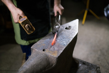 The blacksmith forges the luminous metal in the furnace, kicks out the sparks