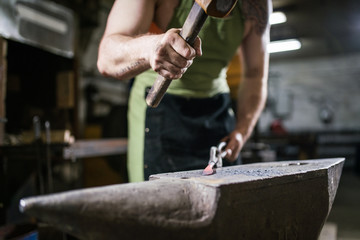The blacksmith forges the luminous metal in the furnace, kicks out the sparks