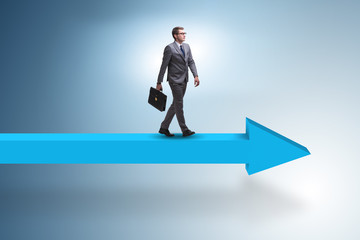 Fototapeta premium Businessman walking on arrow in business concept