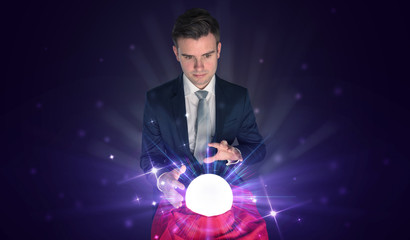 Fototapeta premium Young businessman sitting with crystal ball in action
