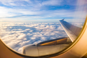 Fototapeta premium błękitne niebo, słońce i chmura za oknem samolotu