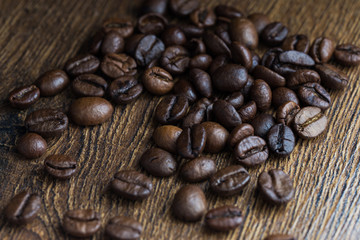 Texture of coffee beans on a wooden background close-up.