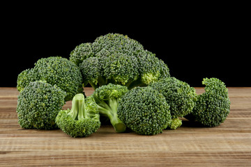 broccoli on a wooden table isolated on a black background