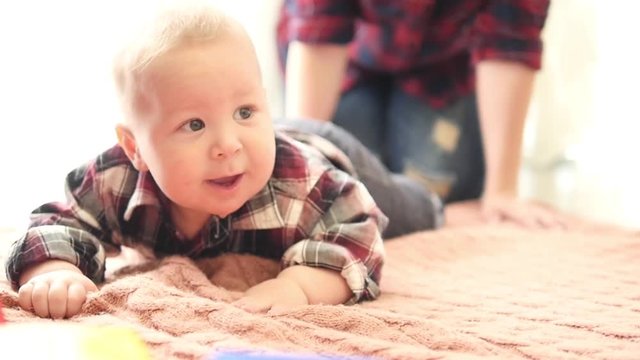 cute smiling baby boy with dimples on cheeks and in star pyjamas crawling on floor