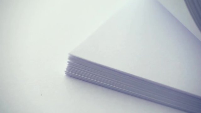 Stack of white paper on table in slow motion