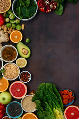 Top view set clean eating. Vegetarian healthy food - different vegetables and fruits, superfood, seeds, cereal, leaf vegetable on dark background with border. Flat lay