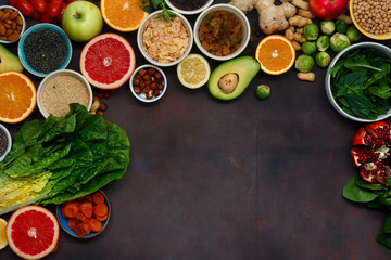Fototapeta na wymiar Flat lay clean eating concept. Set vegetarian healthy food - different vegetables and fruits, superfood, seeds, cereal, leaf vegetable on dark background with copy space, top view