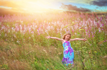 joyful dancing girl in a field of flowers
