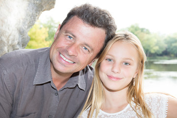 blonde beautiful daughter with cheerful father smiling love in park coast lake